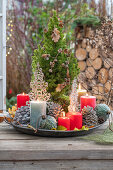 Weihnachtsdeko am Terrassentisch mit Kerzen, Christbaumkugeln, Zapfen, Zuckerhutfichte