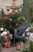 Geschmückter Christbaum neben Sitzplatz auf der Terrasse