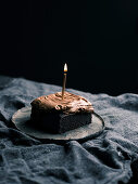 Chocolate cake with chocolate frosting and a birthday candle