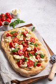Pinsa with tomatoes, mozzarella and basil