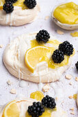 Mini meringues topped with lemon curd and blackberries