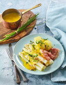 White asparagus with hollandaise sauce and crispy bacon