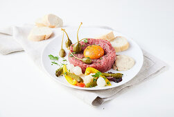 Classic beef tartar with egg yolk and capers