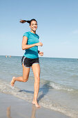 Junge Frau beim Joggen am Meer