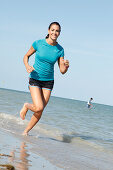 Young woman jogging by the sea