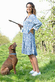 Brunette woman with dog in the garden
