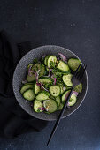 Cucumber salad with red onions, chopped nuts, and parsley