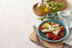 Marinated sea bass fillets with roasted peppers and olives