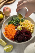 Raw vegetable plate with apple, beets, carrots, and kale