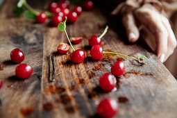 Rote Kirschen und Haarnadel auf Holzbrett