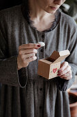 Frau hält Advents-Geschenkbox und Snowball Cookies