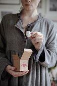 Frau hält Advents-Geschenkbox mit Snowball Cookies (Schneeballplätzchen)