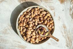 Organic pistachios in a ceramic bowl on a rustic wooden table