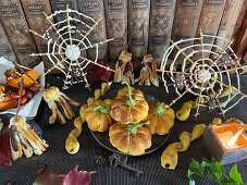 Stuffed mini pumpkin pie, snake-shaped pretzel sticks and chocolate broom and spider web for Halloween