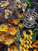 Stuffed mini pumpkin pie, snake-shaped pretzel sticks and chocolate broom and spider web for Halloween