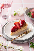 Ein Stück Vanillepudding-Tarte mit frischen Erdbeeren