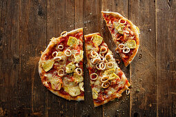 Sauerteig-Pizza mit Tomatensauce, Pancetta, Calamaretti und Artischocken