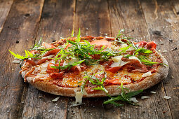 Whole wheat pizza with four types of cheese, sun-dried tomatoes, bresaola and arugula