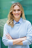 Young blonde woman wearing light-coloured shirt and jumper