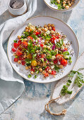 Fresh spring salad with quinoa, chickpeas, cucumber and tomatoes