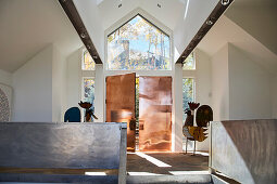 Doors covered in copper and two tin rooster figures in the entrance area