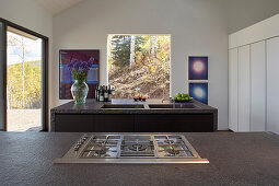 Two kitchen islands with gas stove and sinks in front of the terrace access