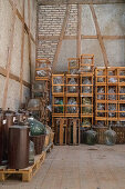Warehouse with glass balloons and clay pots in a distillery