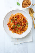 Vegan pasta with tomato and pepper sauce and fried onions