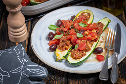 Baked courgettes stuffed with chicken and feta, served with fresh diced tomatoes