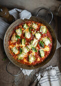 Gratinated courgette and soya mince rolls in tomato sauce