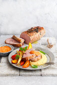 Pork loin with colourful oven vegetables and creamy polenta