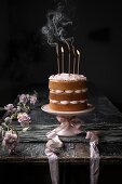 Vanilla naked cake with pink icing and candles