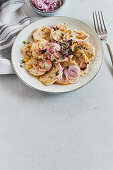 Dumpling carpaccio with parsley and red onions