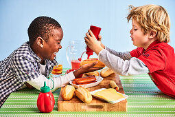 Two boys preparing hot dogs