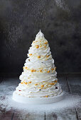 Four-tier Pavlova cake with berry filling and mascarpone cream in the shape of a Christmas tree