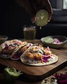 Tacos with beer battered fish, red cabbage salad, pickled onions and hot sauce