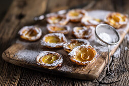 Mini puff pastry apple tartlets with icing sugar