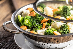 Broccoli, carrots and cauliflower in a stainless steel steamer