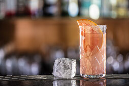 Three Paloma cocktails, garnished with grapefruit and rosemary