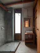 Badezimmer mit Dusche, Waschbecken und Holzelementen, minimalistisches Design