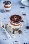 Layered caramel dessert with whipped cream and chocolate