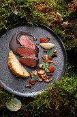 Saddle of venison with nougat-cinnamon jus and celeriac in nut-crunch breading