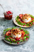Goat's cheese taler with honey and bacon crumble on rocket salad and plum carpaccio