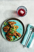 Roasted chicken wings with coriander and a glass of cherry cocktail