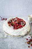 Pavlova mit roten Sommerbeeren und Sahne