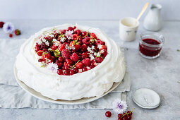 Pavlova mit roten Sommerbeeren und Sahne