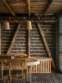 Dining table with chairs and bench in bamboo construction and thatch house