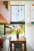 Dining table with chairs and view of the garden through floor-to-ceiling windows