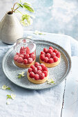 Raspberry tartlets with almond base and cream filling