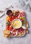 Cheese fondue with vegetables, salami, mortadella and bread